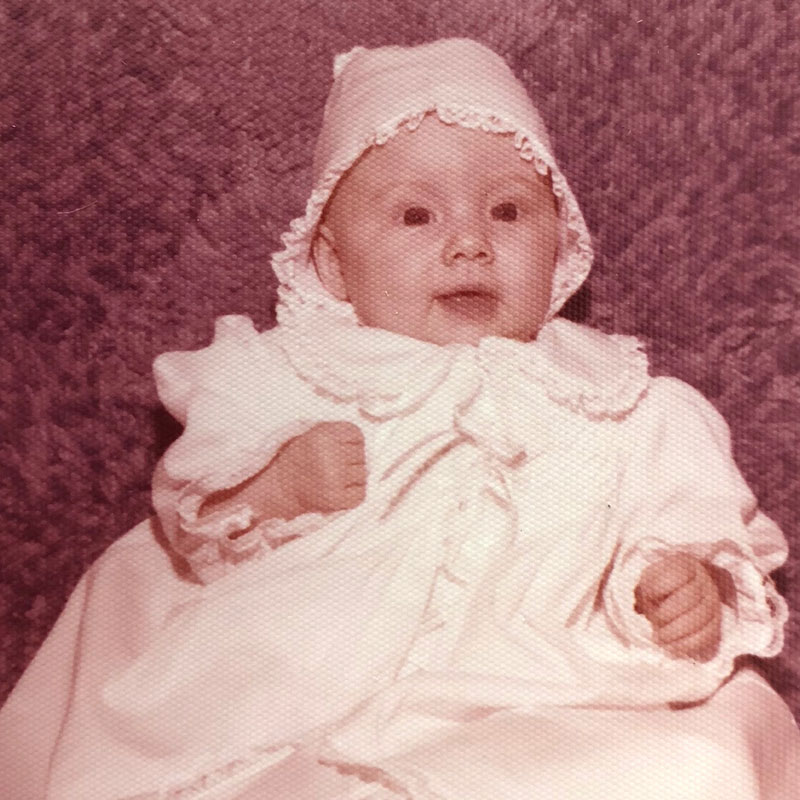 kellie-b1-i1 A baby wearing a white outfit