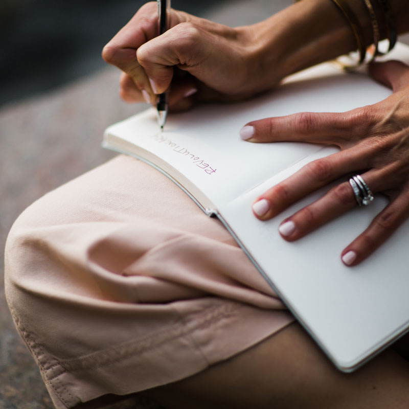A woman writing on a notebook